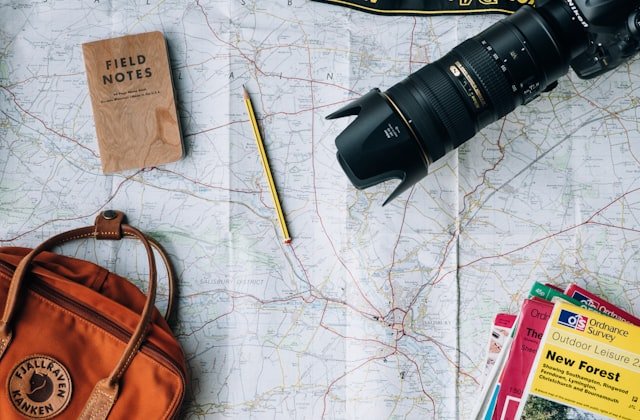 Travel map, camera and backpack laid out for trip planning